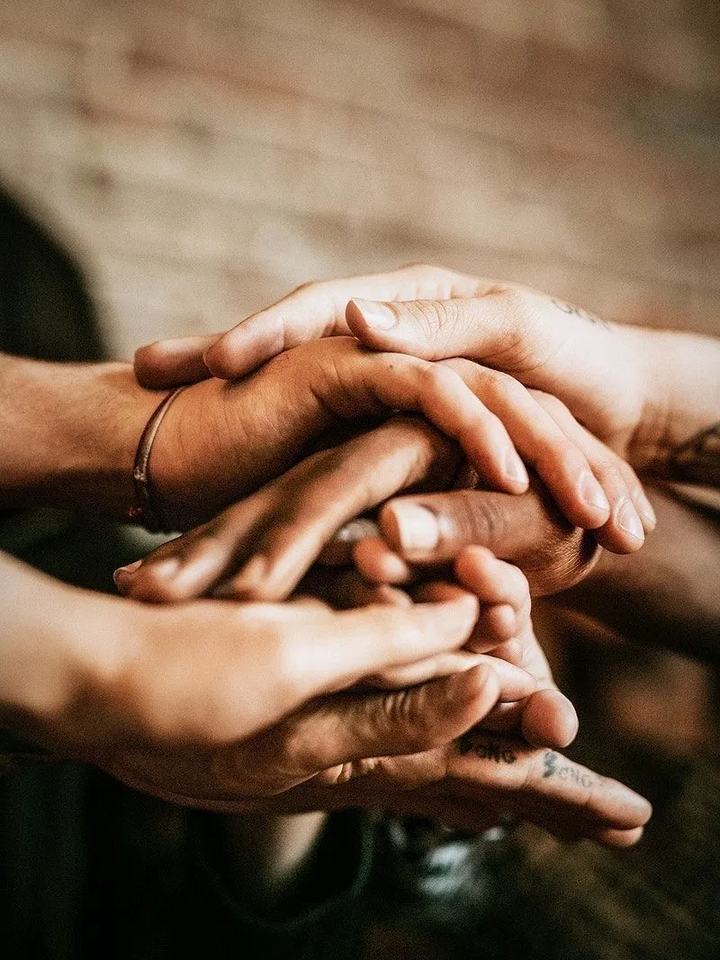 M&atilde;os de v&aacute;rias pessoas sobrepostas umas sobre as outras, em um gesto de uni&atilde;o